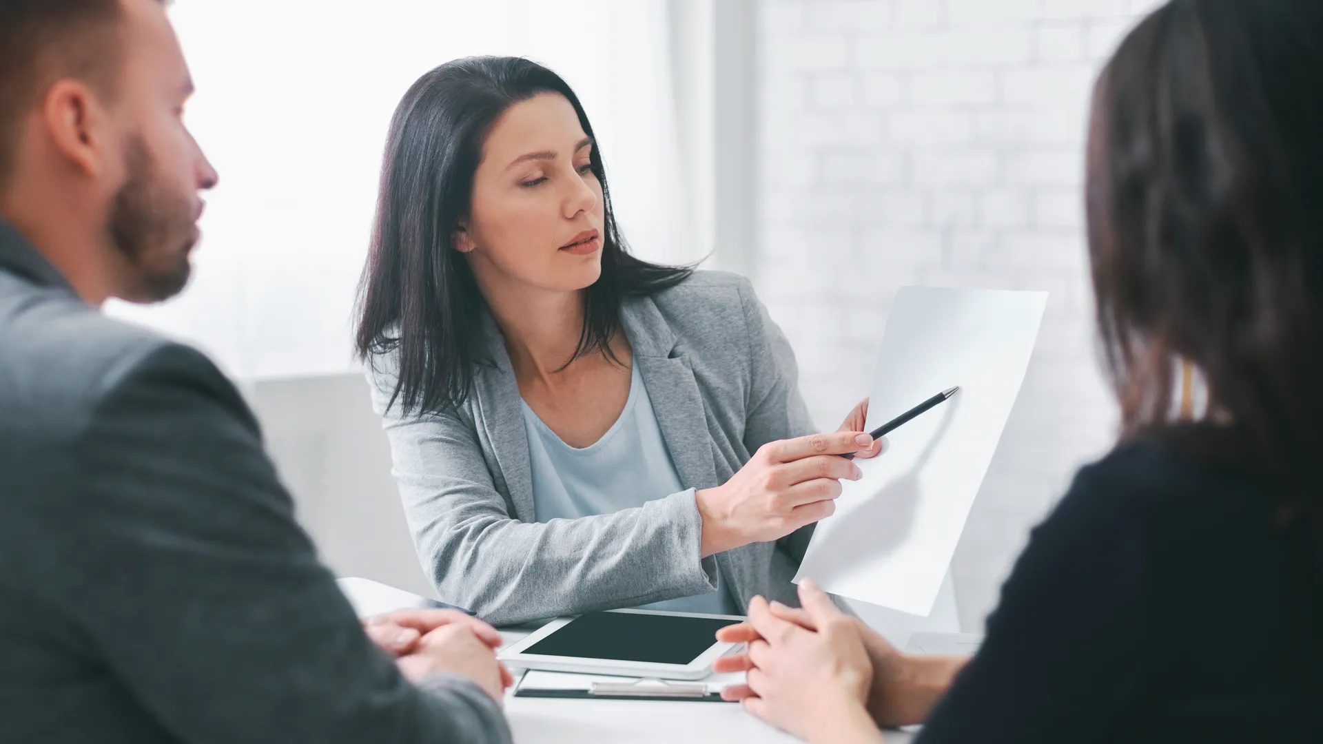 An adviser walking clients through findings across a meeting table