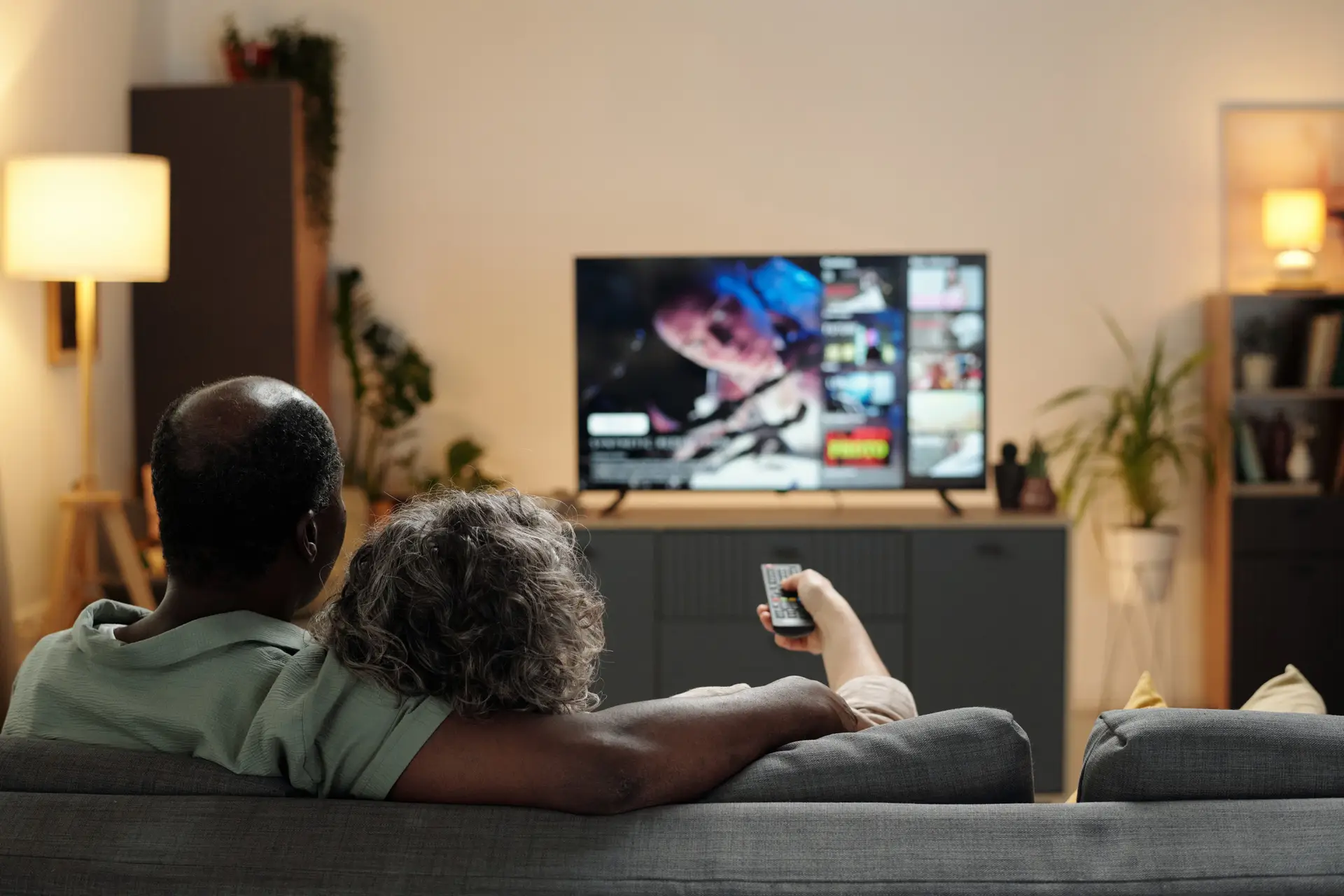 A couple on a sofa choosing what to stream on the television