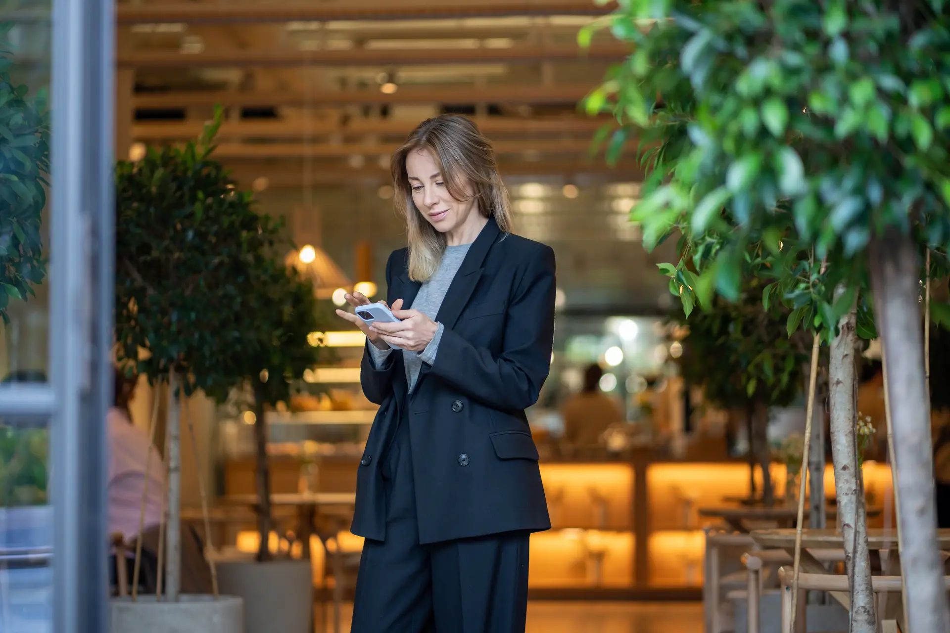 A woman reading her phone in a dimly lit cafe
