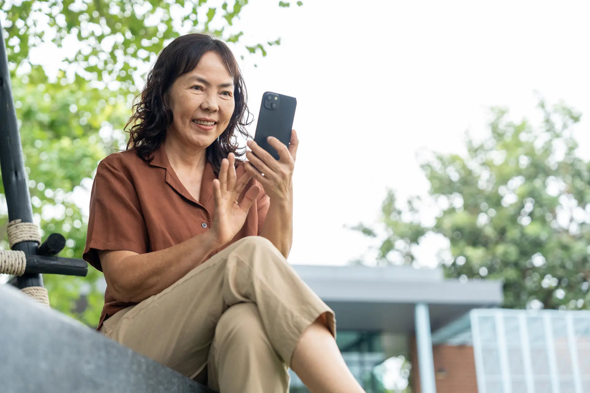 A woman outdoors on a video call on her phone